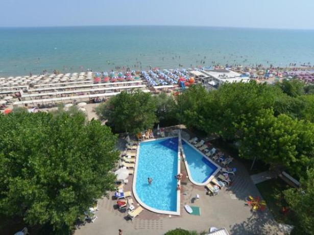 Vista dall'alto di una piscina e una spiaggia affollata.