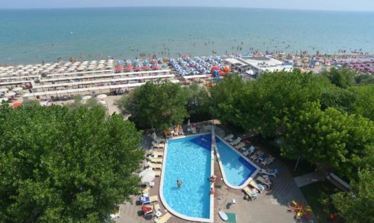 Luftaufnahme eines Pools und eines überfüllten Strandes.