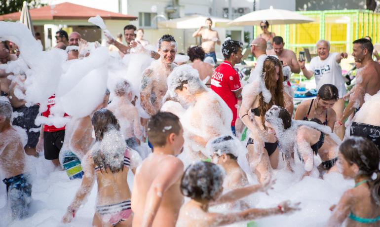 People enjoying a foam party outdoors.