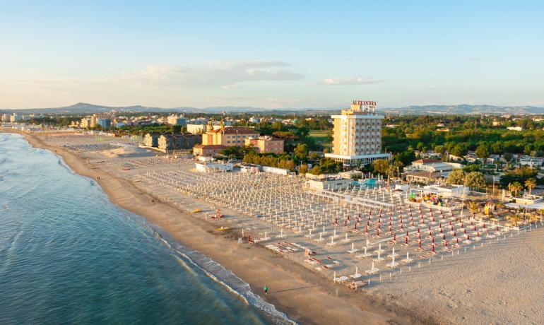 Beach with umbrellas, hotel, and panoramic view at sunset.